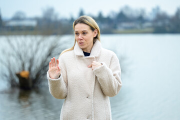 Woman Gesturing Beside Lake