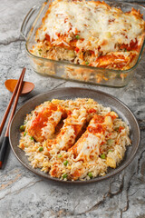 Baked Pork Chop Rice is a delicious casserole цшер egg fried rice, pork chops and a tomato gravy topped with melted cheese closeup in a plate on the table. Vertical