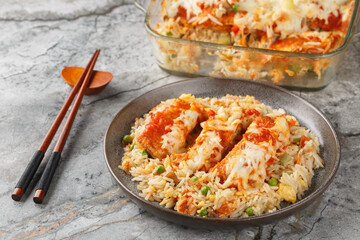 Hong Kong food baked pork chop with fried rice, tomato sauce and melted cheese on top close-up in plate on table. horizontal