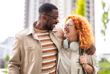 Joyful couple enjoying a sunny day outdoors in an urban setting with modern architecture around them