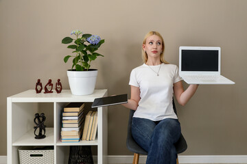 Woman choosing between tablet and laptop in home office