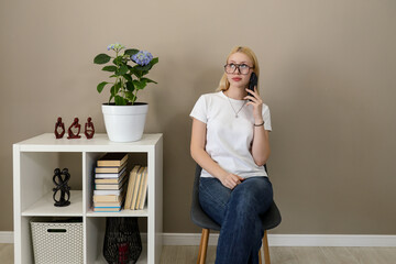 Young woman talking on smartphone in modern home office
