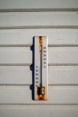 weathered old thermometer on building wall outdoors