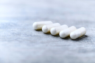 Beta-alanine capsules. Bodybuilding food supplements on wooden background. Soft focus. Close up....