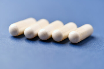 Arginine capsules on bright background. Soft focus. Close up. Copy space.	
