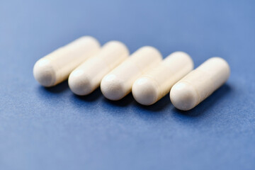 Arginine capsules on bright background. Soft focus. Close up. Copy space.	