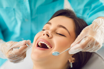 Dentist clinic check up for happy woman with open mouth, healthy smile, teeth regular exam. Doctor...