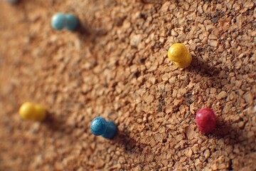 Close-up of colorful pushpins in corkboard