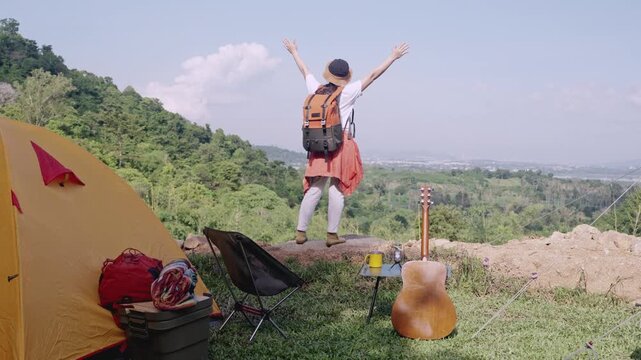 Asian woman camping alone with tent on summer holiday. Outdoor activity and lifestyle.