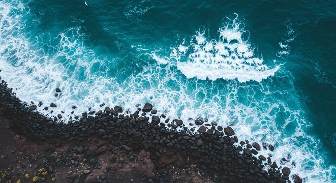 Aerial view of ocean waves crashing against rocky coastline