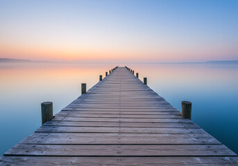Fototapeta premium Wooden pier stretching into a calm ocean at sunset, peaceful escape