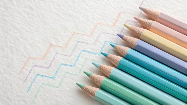 A closeup of pastel colored pencils drawing a zigzag pattern on textured paper, showcasing a spectrum of creative hues - Powered by Adobe