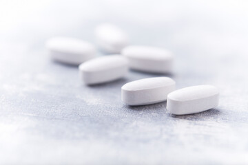 Amino acids tablets on wooden background. Soft focus. Close up	
