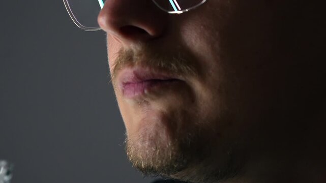 Close-up of a man swallowing a capsule with omega-3 and fish oil and washing it down with a glass of water.
Use of medications and vitamins.
Omega 3 in the human mouth
