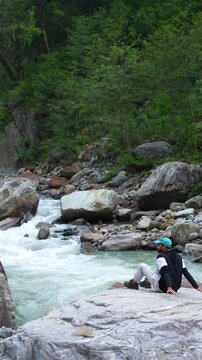 An Indian man looking at the Mandakini River while trekking to the Kedarnath Temple in Kedarnath, Uttarakhand, India.