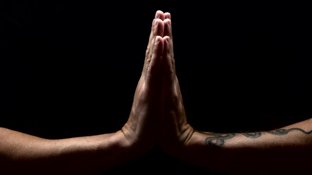 Praying hands on a black background, close-up.
Namaste gesture performed by an Indian man.
Indian prayer or meditation.
Yoga and prayer to Buddha.