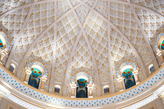 Detailed architectural dome with intricate patterns and colorful stained glass windows, showcasing opulent and ornate design.