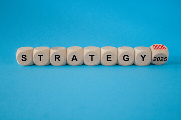 Turned a cube and changes words Strategy 2025 to Strategy 2026. Beautiful blue background. Business...