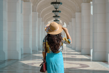 luxurious corridor with stone arches and columns in perspective with a woman walking, travel and...