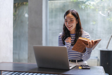 Young teacher giving online class using laptop and book