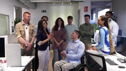 Diverse office team celebrating professional achievement, warmly clapping and supporting disabled colleague during workplace milestone moment - Powered by Adobe