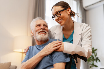 Doctor comforting senior man sitting in wheelchair at home or nursing home