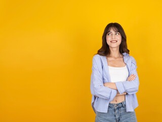 Portrait of young caucasian 20s woman girl student standing with crossed arms isolated on yellow...