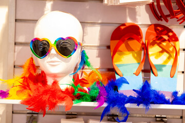 Beach style, LGBT mannequin in glitter and feathers with colored glasses and rainbow colored flip...