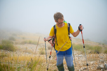 Man Hiking Through a Foggy Landscape