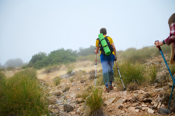 Hikers Trekking through a Misty Mountain Trail Surrounded by Scenic Nature