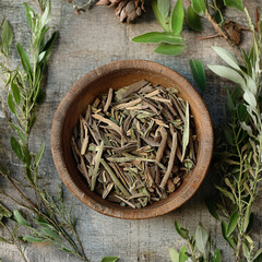 Rustic Herbal Remedy Still Life: Wooden Bowl with Dried Herbs and Greenery