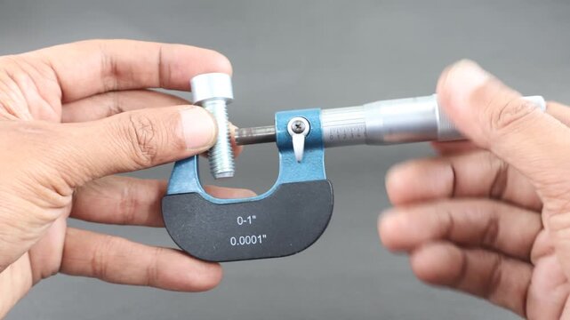 Hand measure diameter hex bolt using screw micrometer on black background. Universal tool for high-precision measurements of external and internal dimensions. Measurement tool.