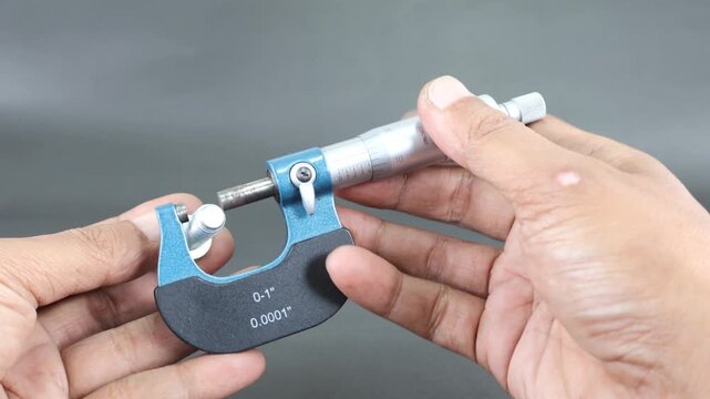 Hand measure diameter hex bolt using screw micrometer on black background. Universal tool for high-precision measurements of external and internal dimensions. Measurement tool.
