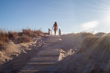 Young woman among the dunes at sunset