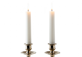 Two white candles burning brightly in ornate brass holders, isolated on white isolated on transparent background