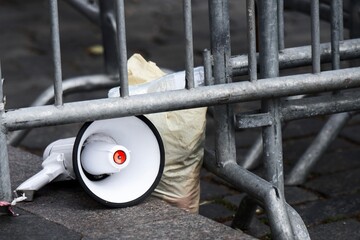Portable loudspeaker discarded near trash bags and temporary barriers - concept of abandoned...