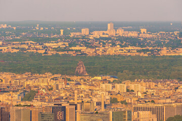 Panoramic view of the Paris skyline and the Bois de Boulogne with the zoo's "Grand Rocher" at sunset.