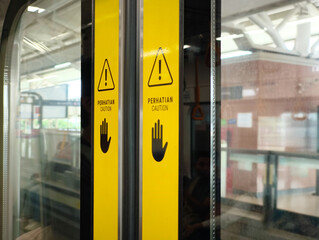 Caution Signs on Train Door with Warning Symbols and Text