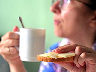 Woman Enjoying Breakfast with Coffee Mug and Cheese Toast in Morning Light