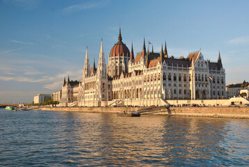 Obraz premium Hungarian Parliament building on the bank of the Danube River in Budapest at sunset.