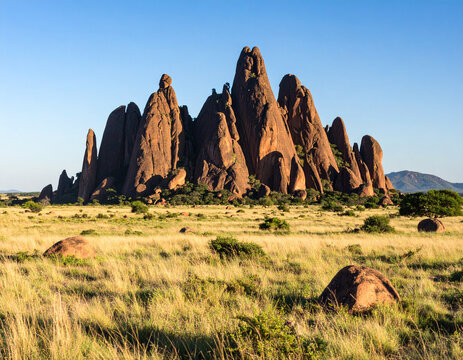 The Black Rocks of Pungo Andongo, imposing and mysterious geological formations, rising from a flat, savanna landscape.