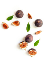 Purple ripe figs fruit and slices with green leaves top view on a white background