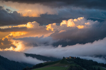 Cloud-draped hillside in under stormy clouds