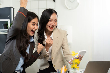 Celebration of Success. Two women excitedly celebrating achievement in a modern office.