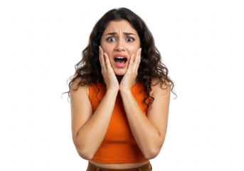 A young woman with curly dark hair expresses extreme fear and shock, holding her hands to her face isolated on transparent background