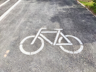 Bicycle lane sign marked on pavement in a city park during daytime displaying clear bike path for...