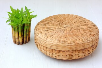 Rustic wicker basket beside a small lucky bamboo plant