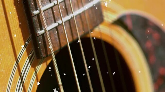 Opening close-up on guitar, star particles drifting and floating over strings creating shimmer