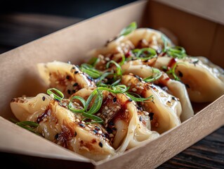 Delicious Asian-style dumplings filled with meat and vegetables served in a brown paper tray garnished with green onions and sesame seeds