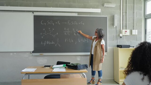 Female professor explaining chemistry lesson To college students learning Tech Science course at High School